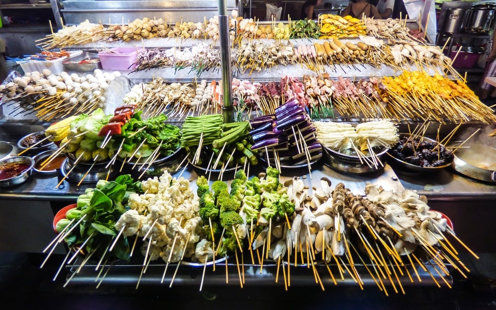meat and vegetables on sticks on a street stall waiting to be grilled safely