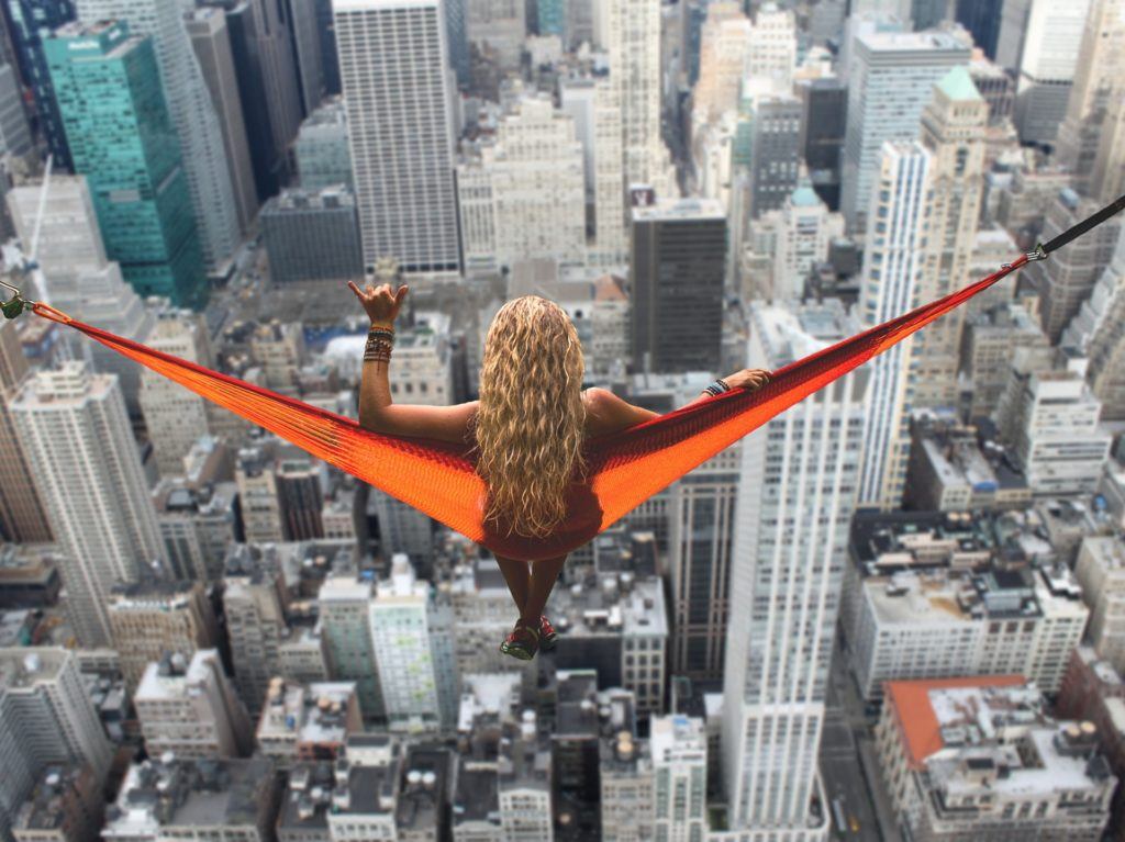 A girl sits in a hammock while travelling solo