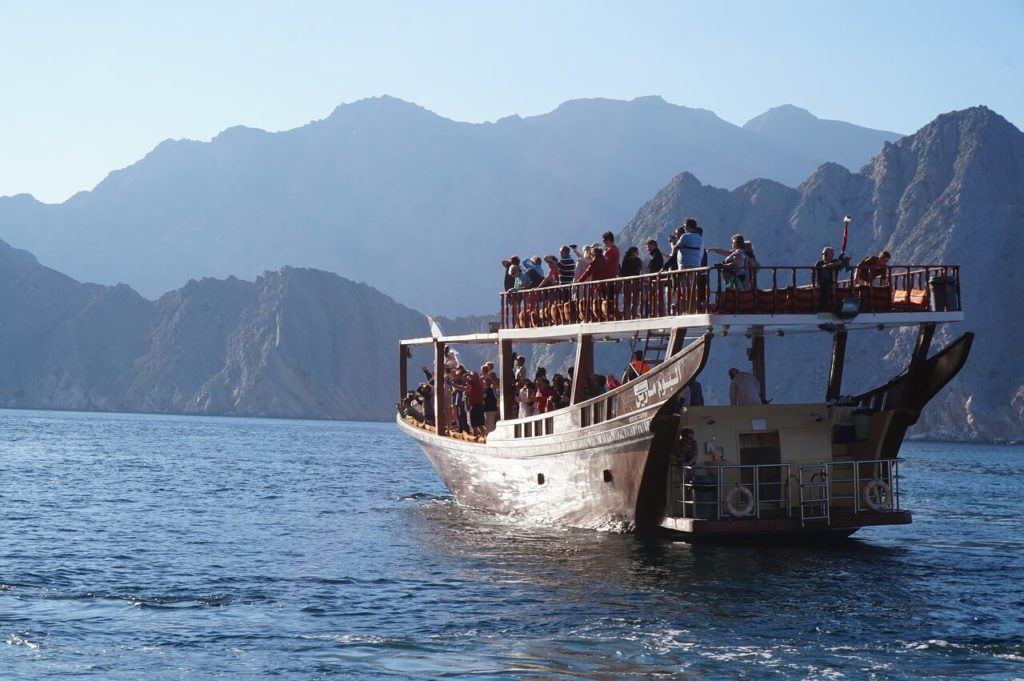 large dhow boat coasting along the blue waters of musandam