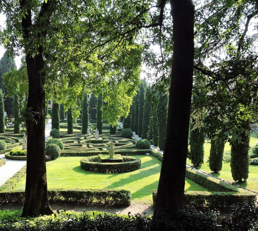 A lovely garden with tidy bushes and trees in the Gardens Of Giardino Giusti in Verona