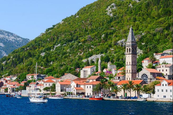 orange and stone homes in front of a fjord and coastline in montenegro