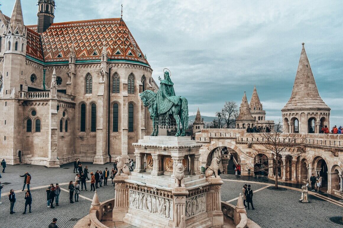 statue of a horse in front of a cathedral in Budapest