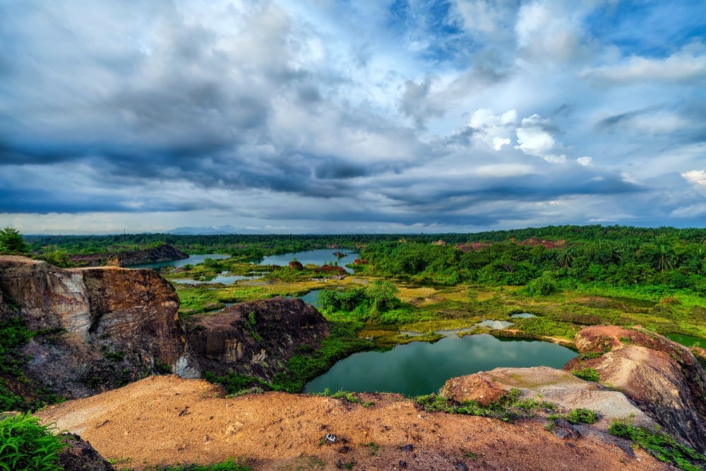 several small dark blue green lakes surrounded by boulders and lush flat jungle called Guar Petai Penang