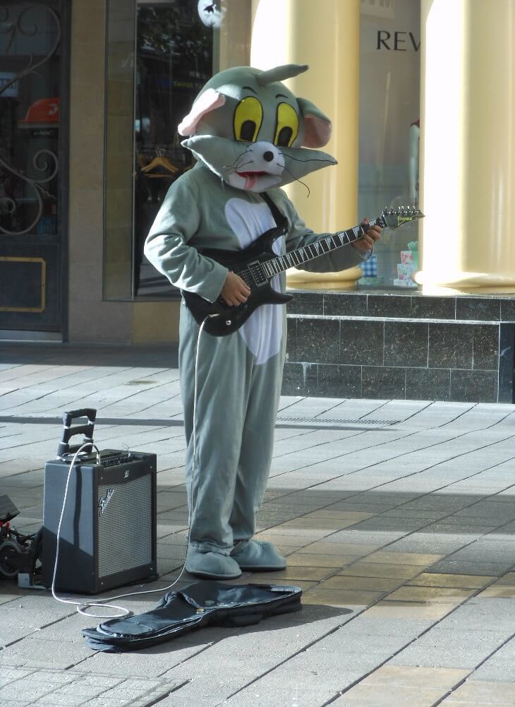 A backpacker busking in a cat costume