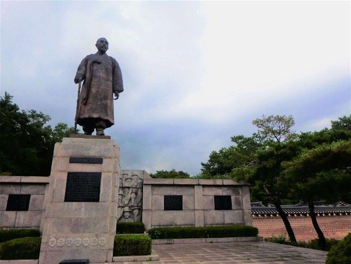 a statue of a man in a robe in seoul south korea