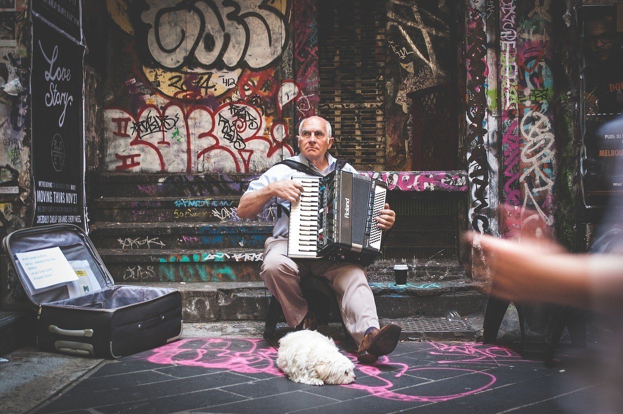 Street performer busking for a living with his best friend