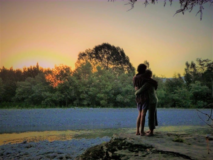 A couple backpacking New Zealand watch a sunset
