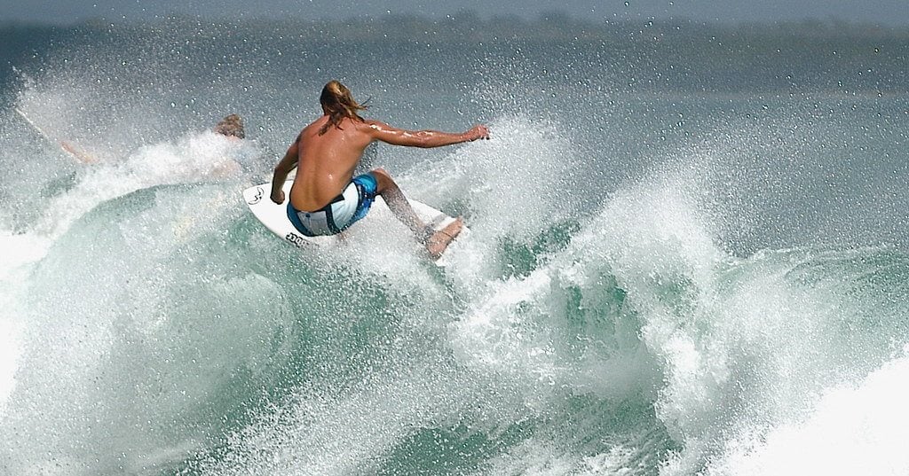 Dude surfing lathered in his sunscreen toiletries