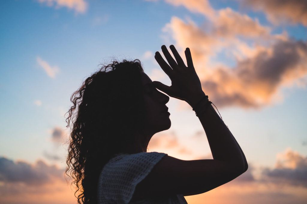 woman practising yoga on the beach at sunset 