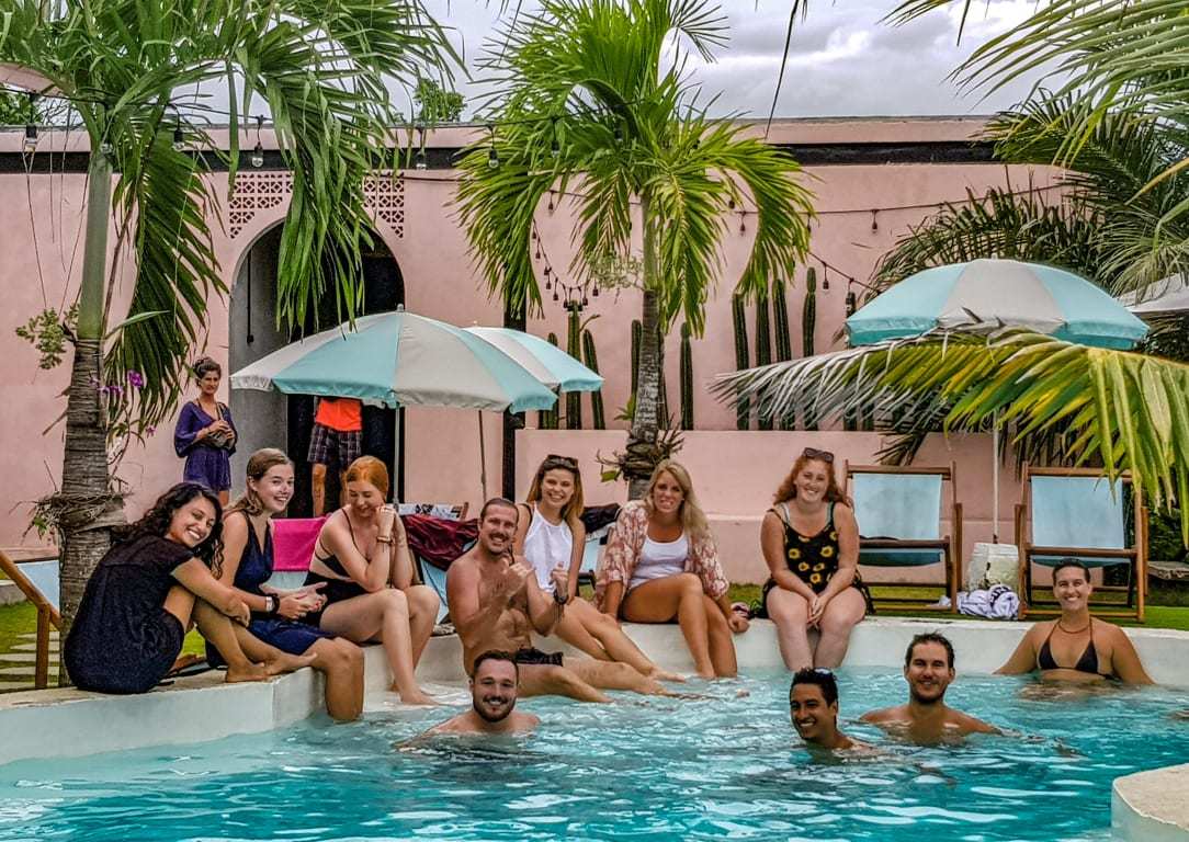 people sitting around the pool having a good time and laughing at Clandestino party hostel best hostels in canggu