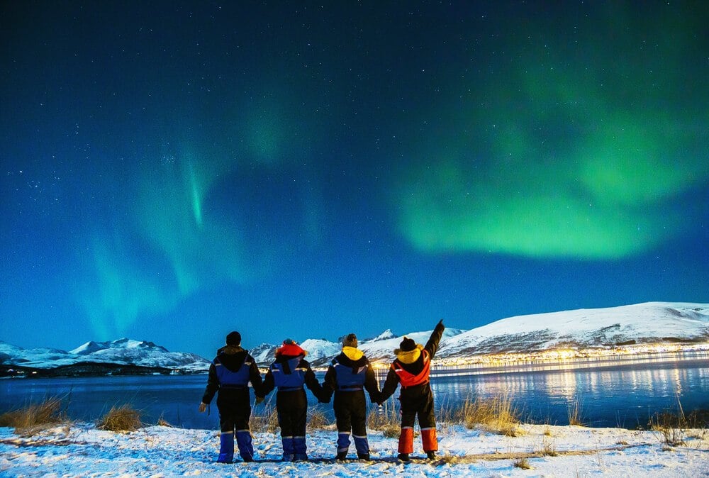 A family travelling in Iceland watches the Northern Lights
