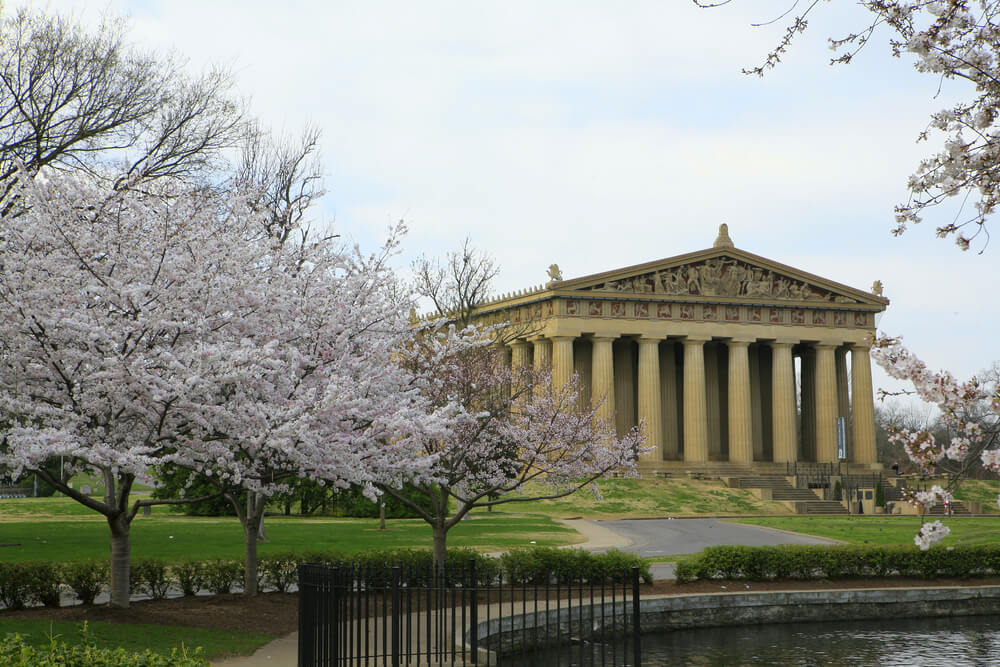 when to visit nashville parthenon building with pink spring flowers

