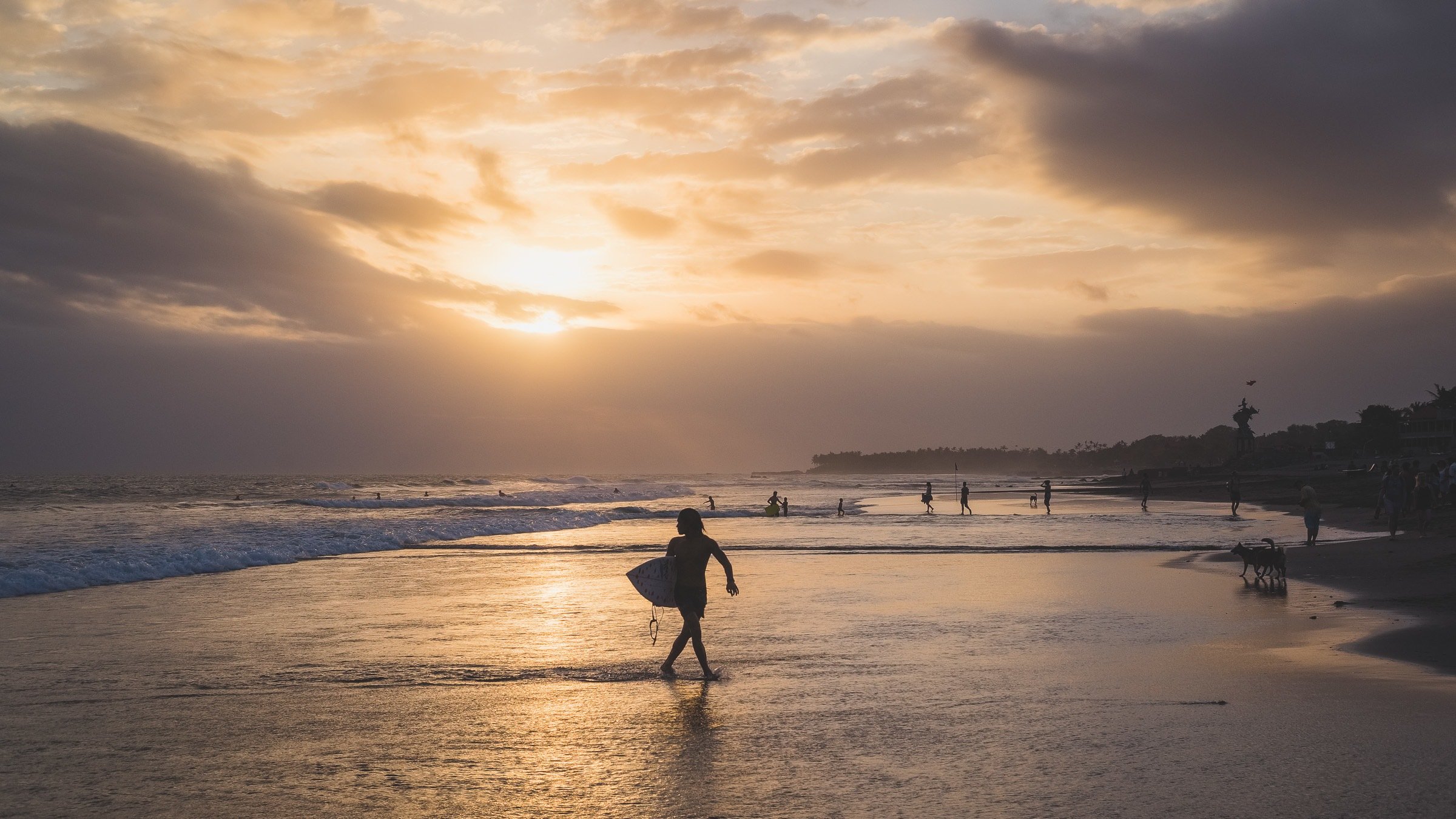 surfer on the beach in canggu at sunset