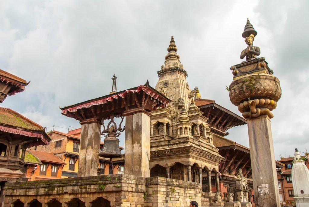 Patan temple in Kathmandu, Nepal, with a tatue of Bhairav and bells hanging from the roof.