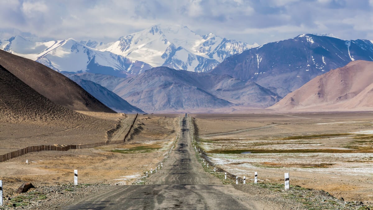 The Pamir Highway extending into the horizon - top bucket list road trips