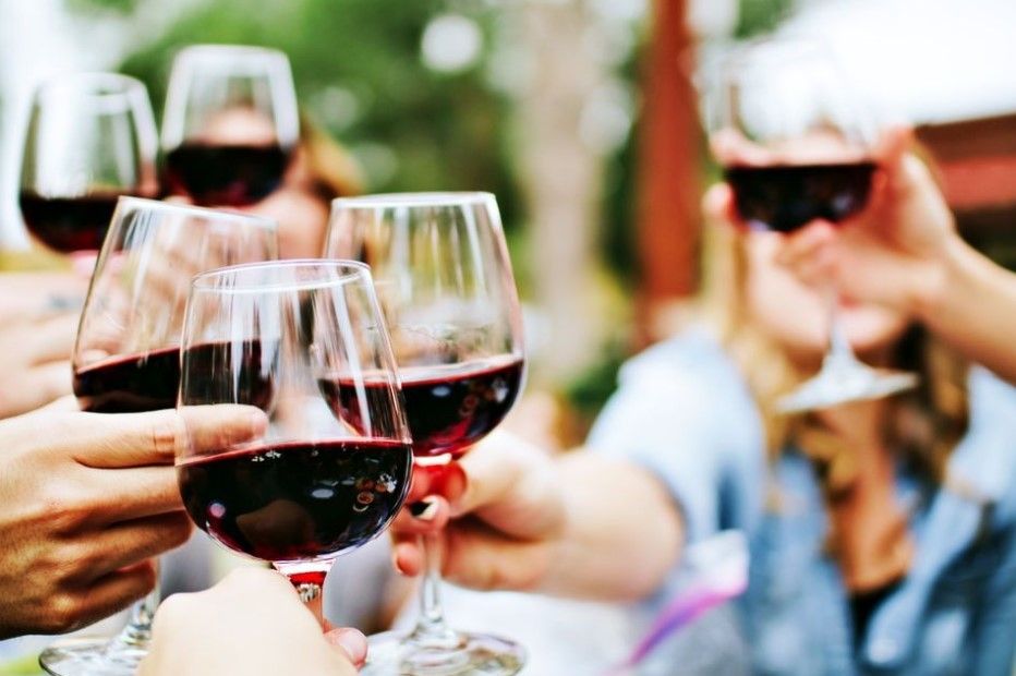 people toasting purple colored wine glasses while traveling in los angeles