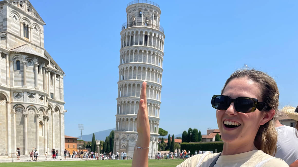 dani trying to hold up the leaning power of pisa, italy
