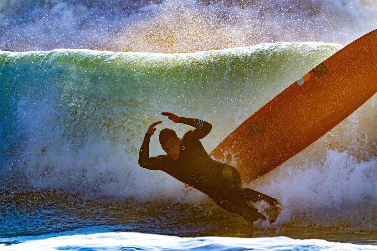 A man surfing in Sri Lanka at Arugam Bay falls off his board