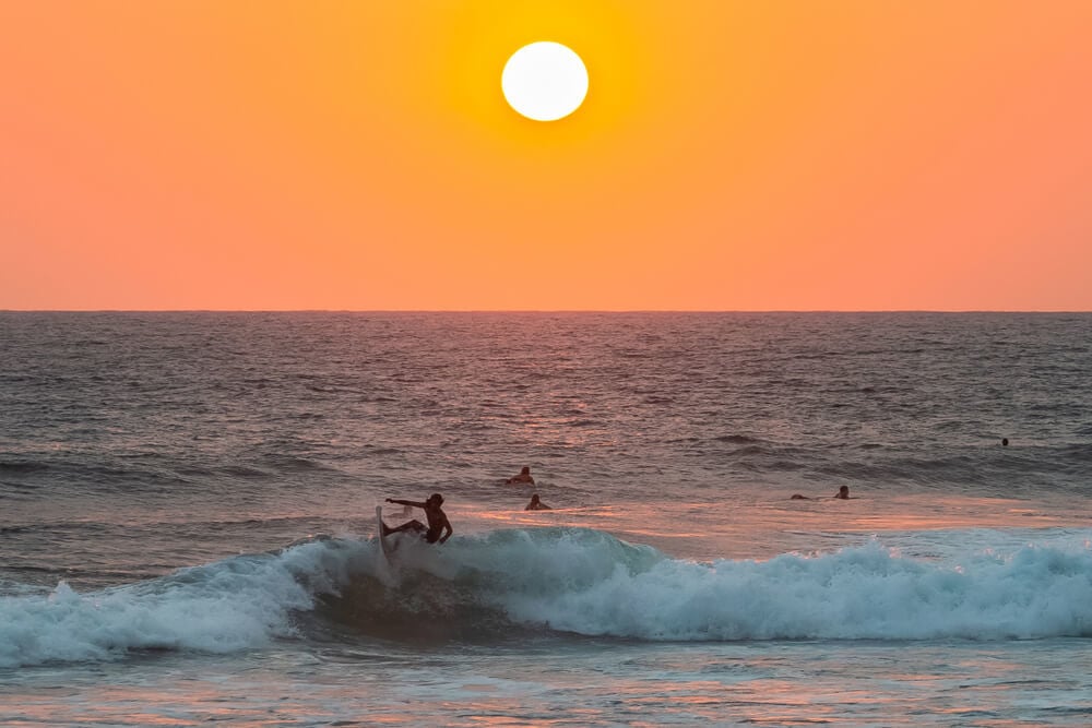 Surfing below a Hikkaduwa sunset