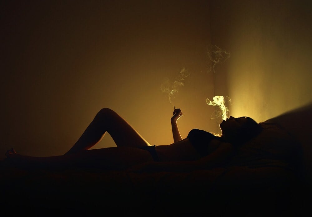 Girl in a hostel having a smoke after a lay