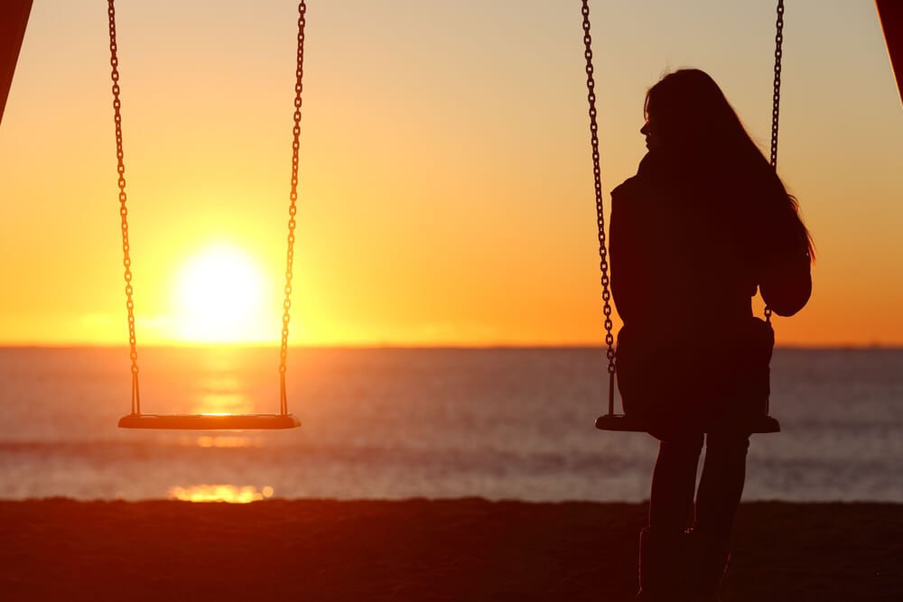 girl on a swing at sunset