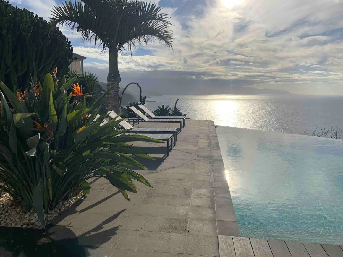 Infinity pool with views directly over the ocean. Sun loungers set up along the side of pool