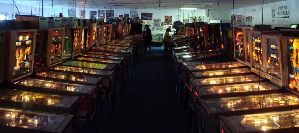 Rows of pinball machines with two players enjoying a game at the Pinball Hall of Fame  
