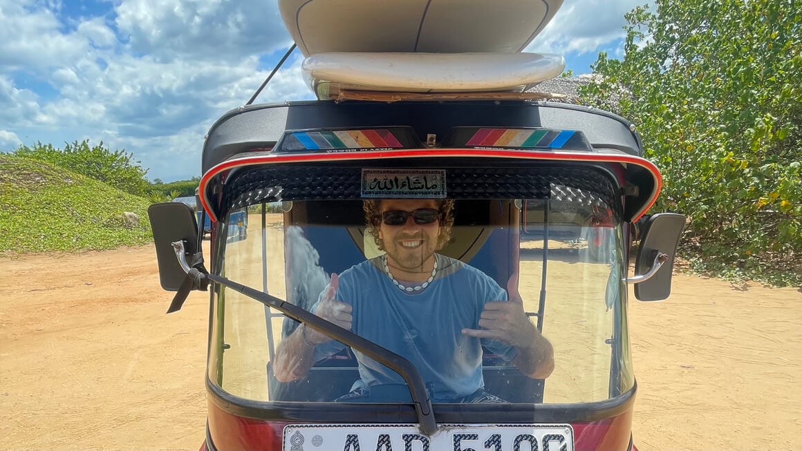 harvey driving a tuktuk in sri lanka with surfboards on top