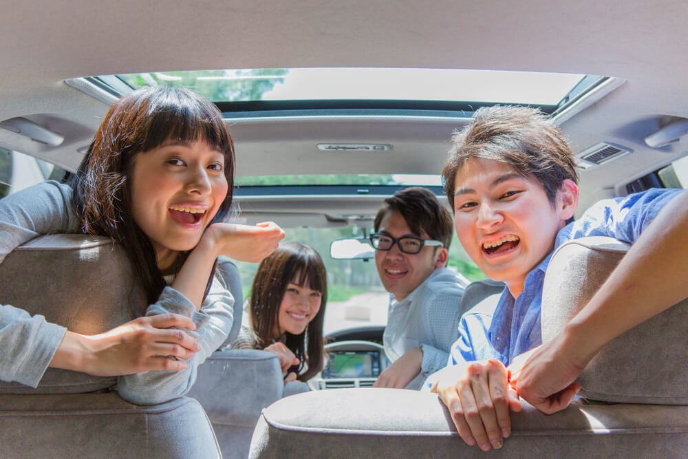 A car full pof Japanese people smiling