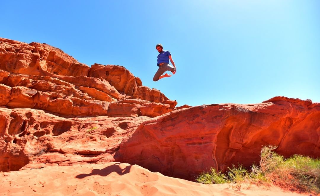 Man doing some desert parkour wile on an Abraham Tour