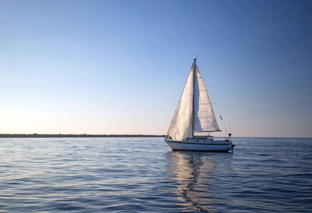 A sailboat makes its way across the ocean in the Cook Islands.