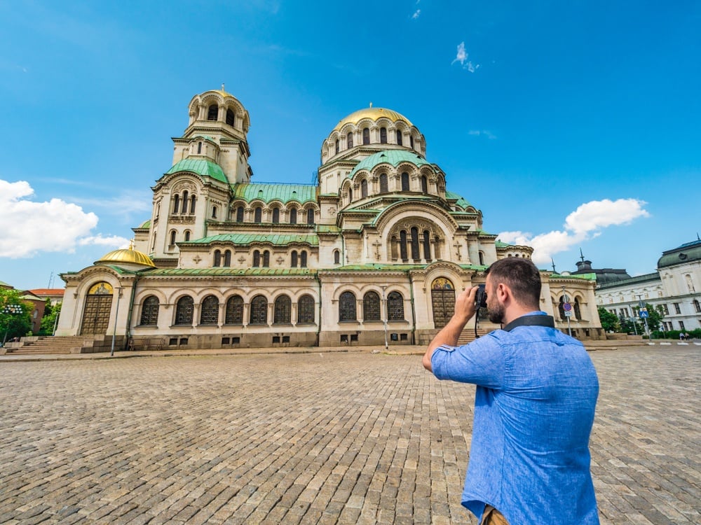 a man taking a photo of a cathedral in bulgaria