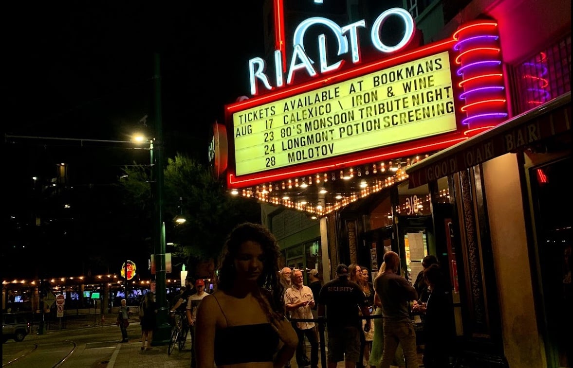 A girl poses for photo outside the famous theatre in Tucson, The Rialto.