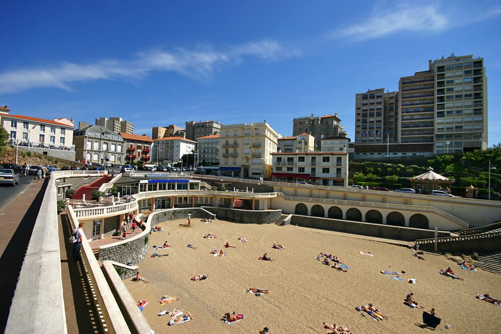 Beach with people subathing, big buildings surrounding beach.  Port Vieux, Biarritz