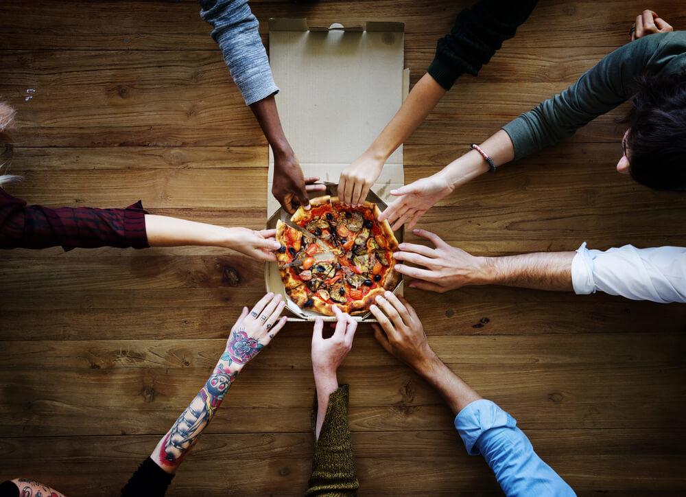 People staying in a European hostel having a pizza party