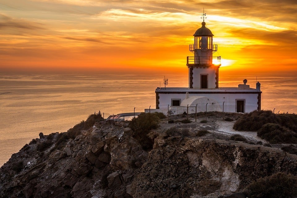 Lightouse and sunset - popular tourist attraction in Santorini, Greece