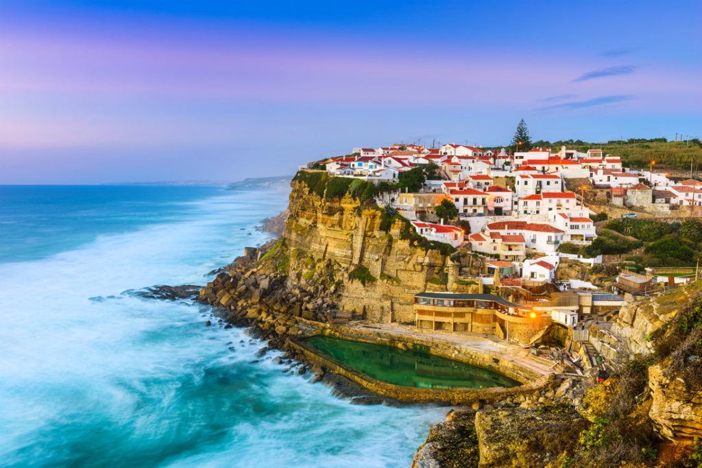 A cliff full of colourful houses on the edge of a cliff in portgual 