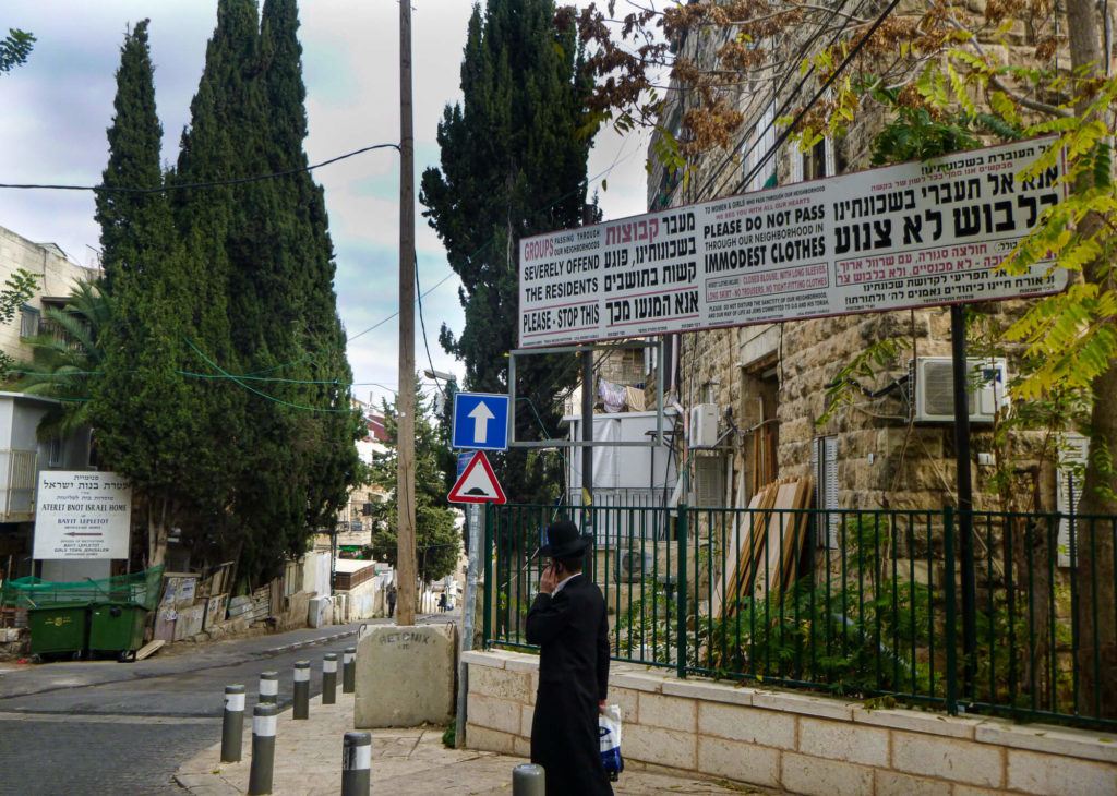 An Ultra-Orthodox Jewish man talking on the phone in a neighborhood in Jerusalem