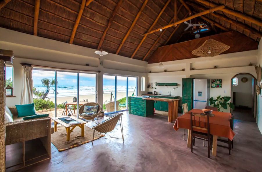 wide open beachhouse with sand and a blue sea right outside what is airbnb