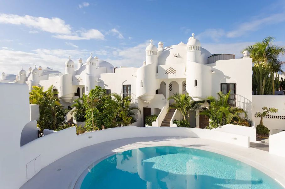 Outdoor pool and view of the white, beautiful property.