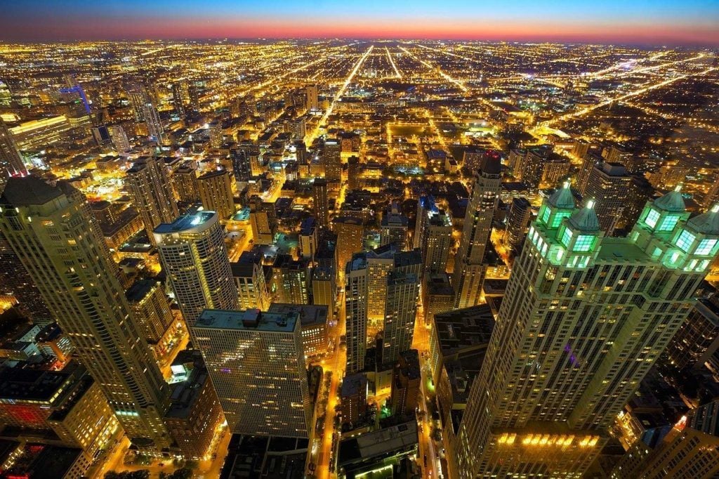 aerial view of chicago at night buildings fully lit up as seen from a chicago airbnb