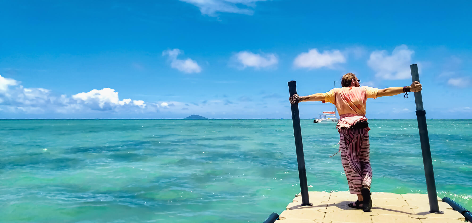 A backpacker poses at a beautiful beach place in North Mauritius