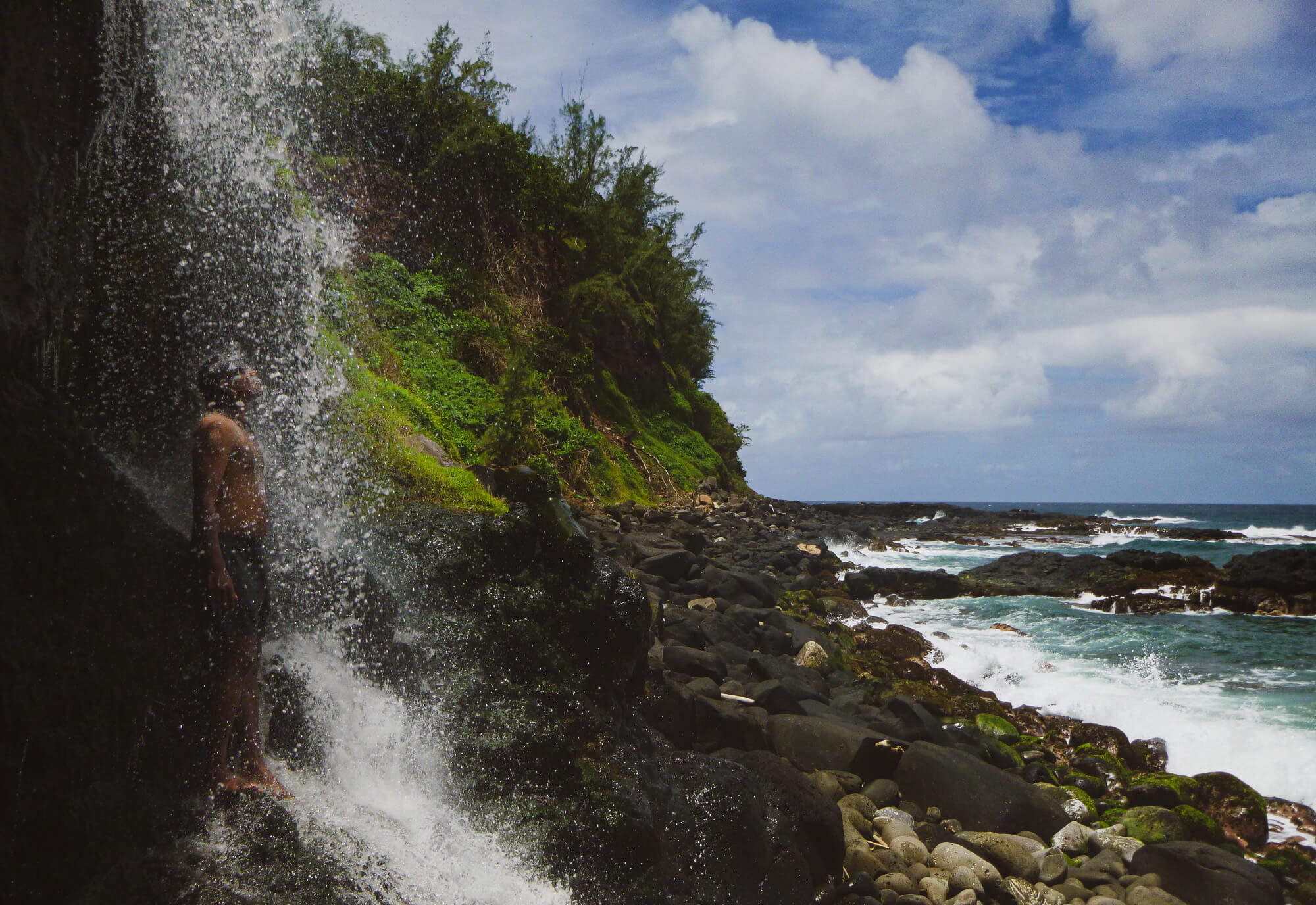 Enjoying a waterfall while hiking on a Mauritius wild beach