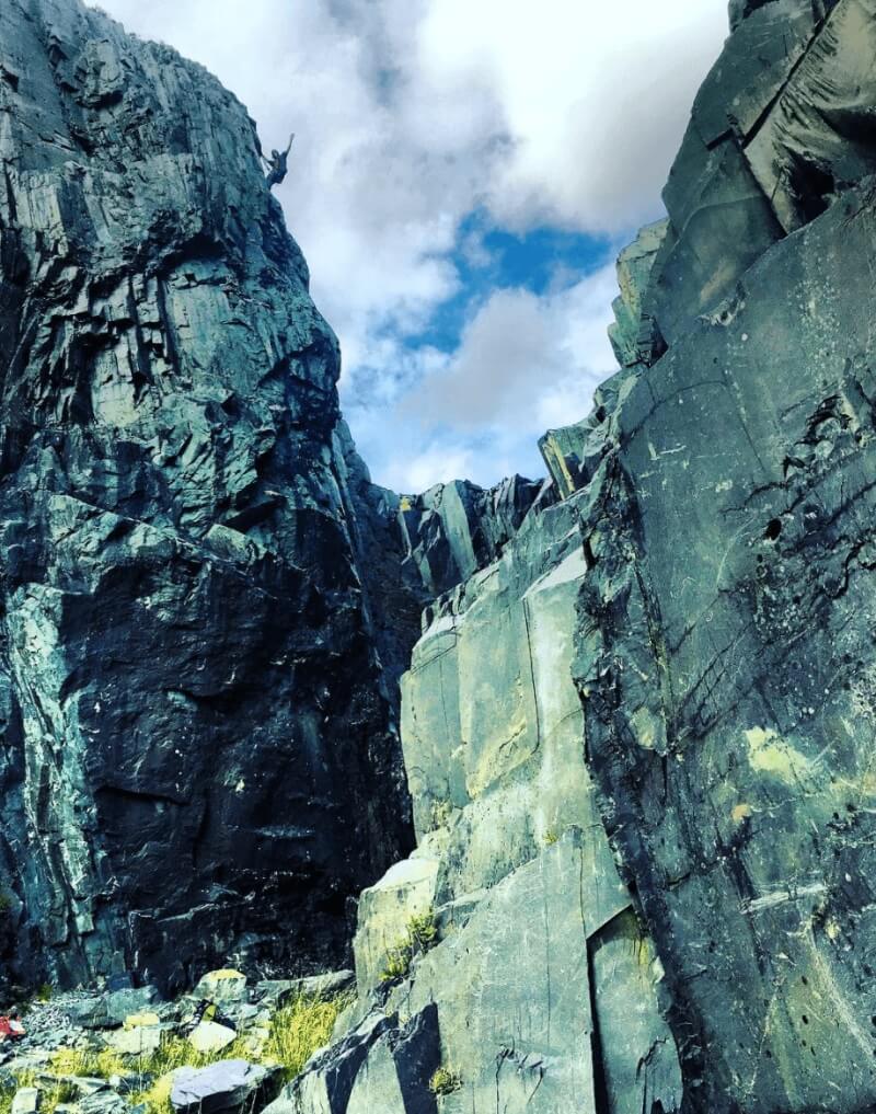 A person climbing high on a cliff