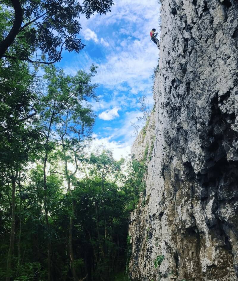 A person climbing high on a cliff