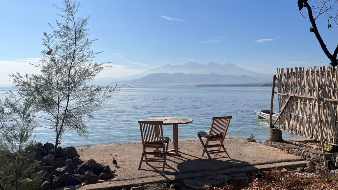 an empty table with a great view on the beach in gili air, indonesia