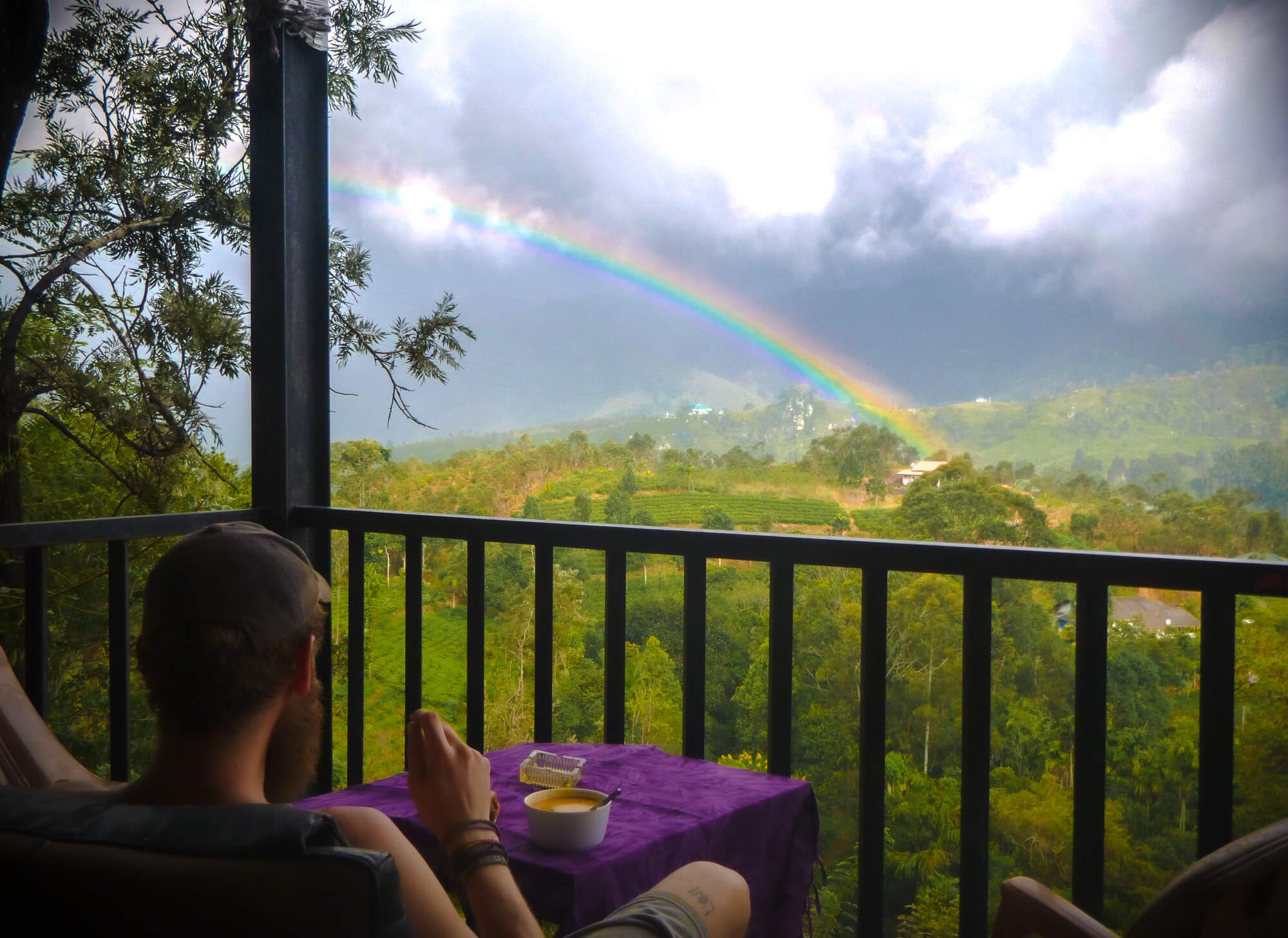 The owner of a sustainable hostel in Sri Lanka enjoys a rainbow over breakfast