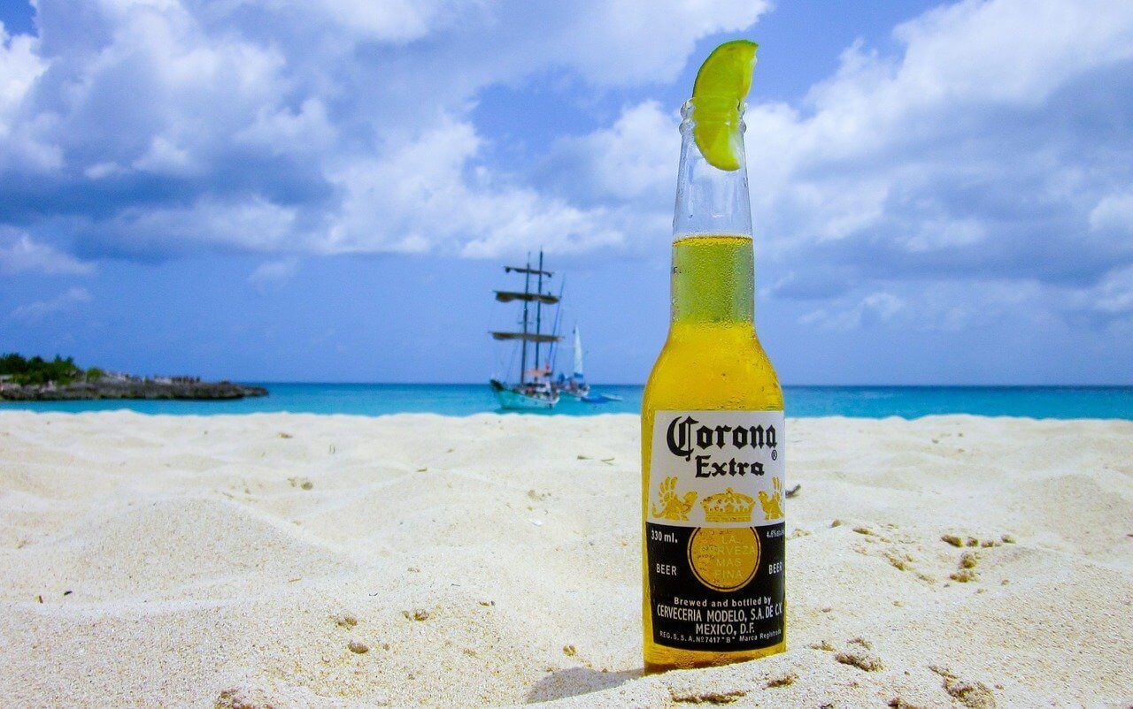 A corona beer and lime on the beach of a country reopened to tourism after COVID lockdowns
