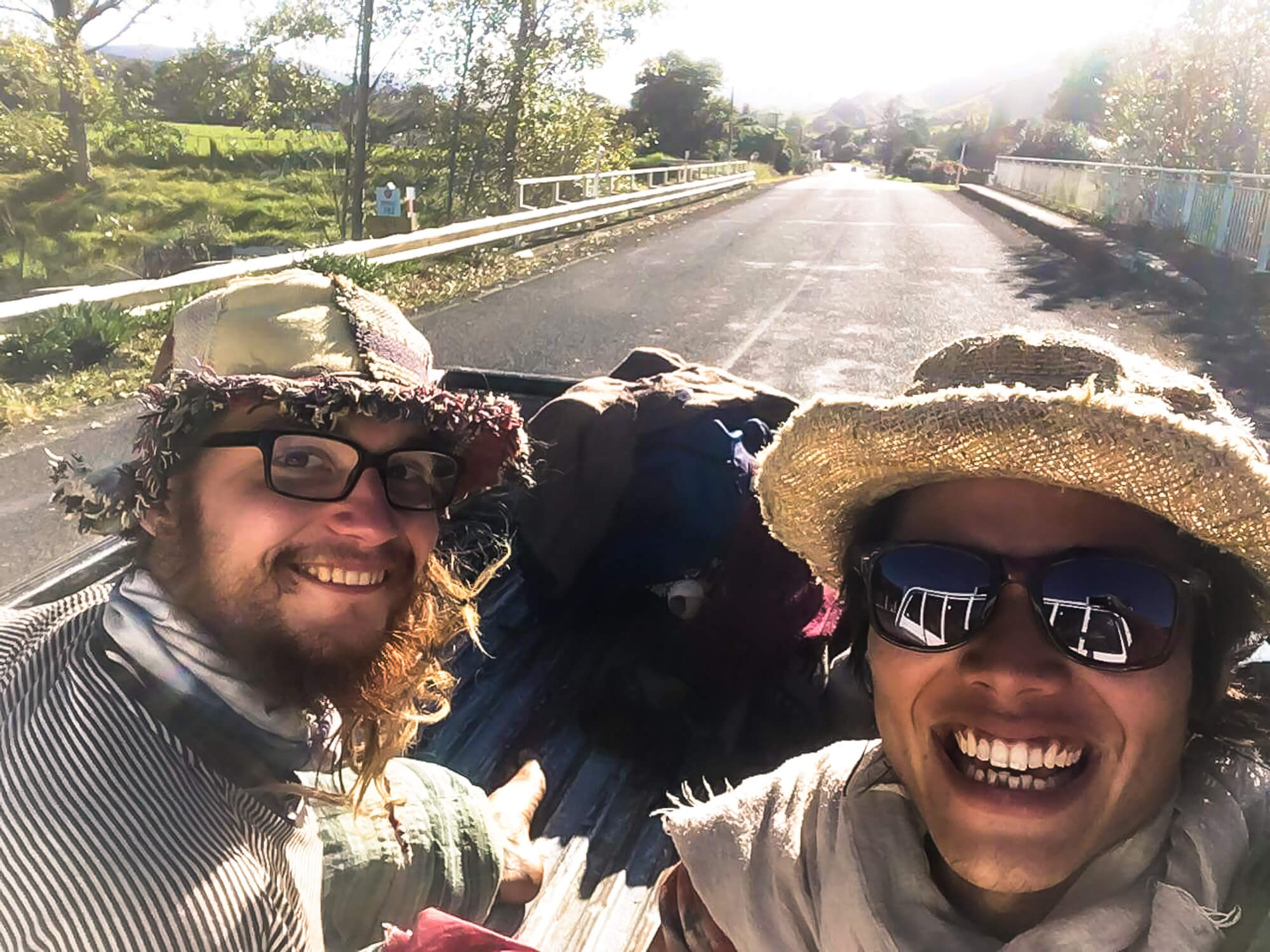 Two travel buddies and friends hitchhiking a truck