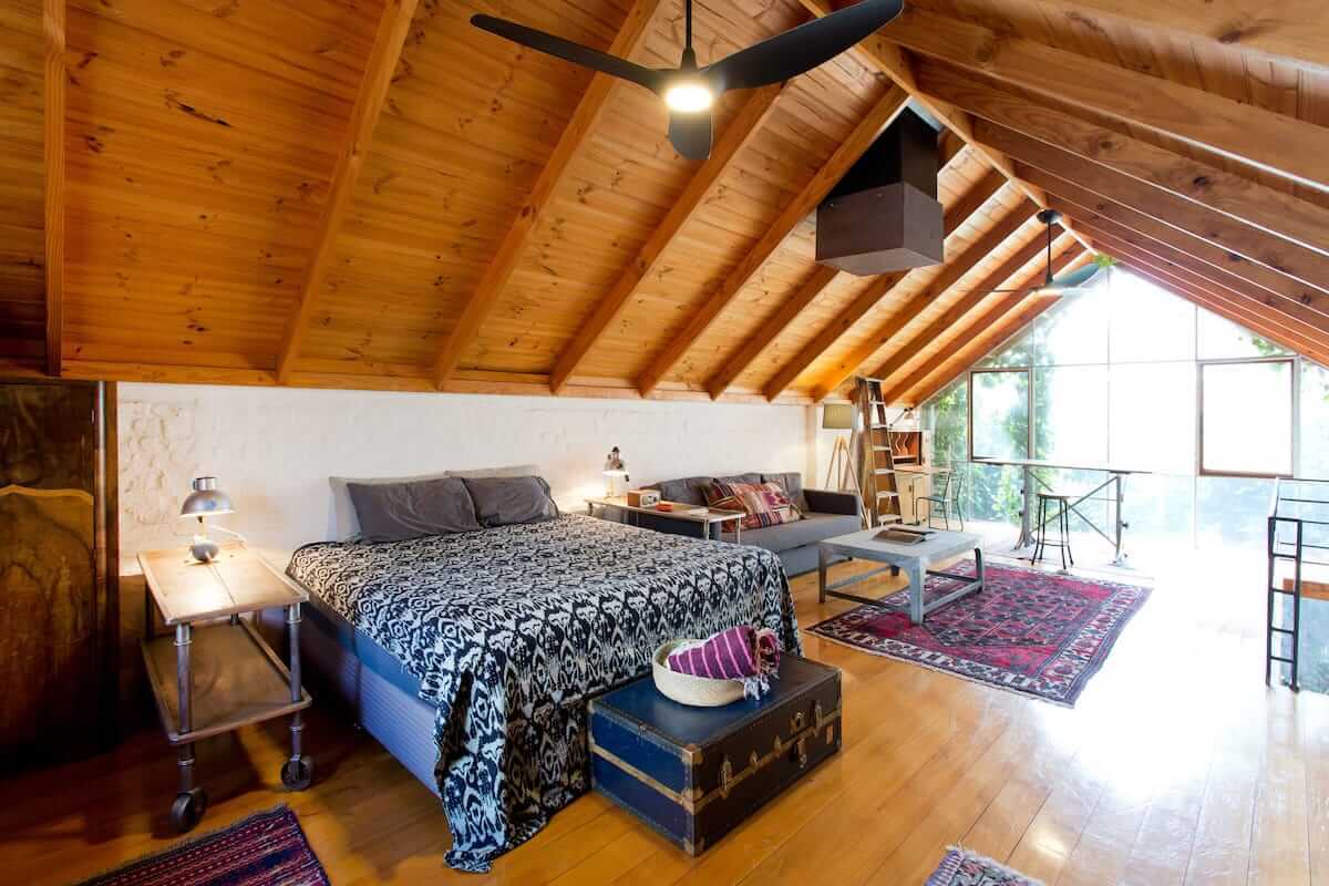 Spacious wooden loft with bed and sofa. Amazing floor to ceiling window at the end of loft. 
